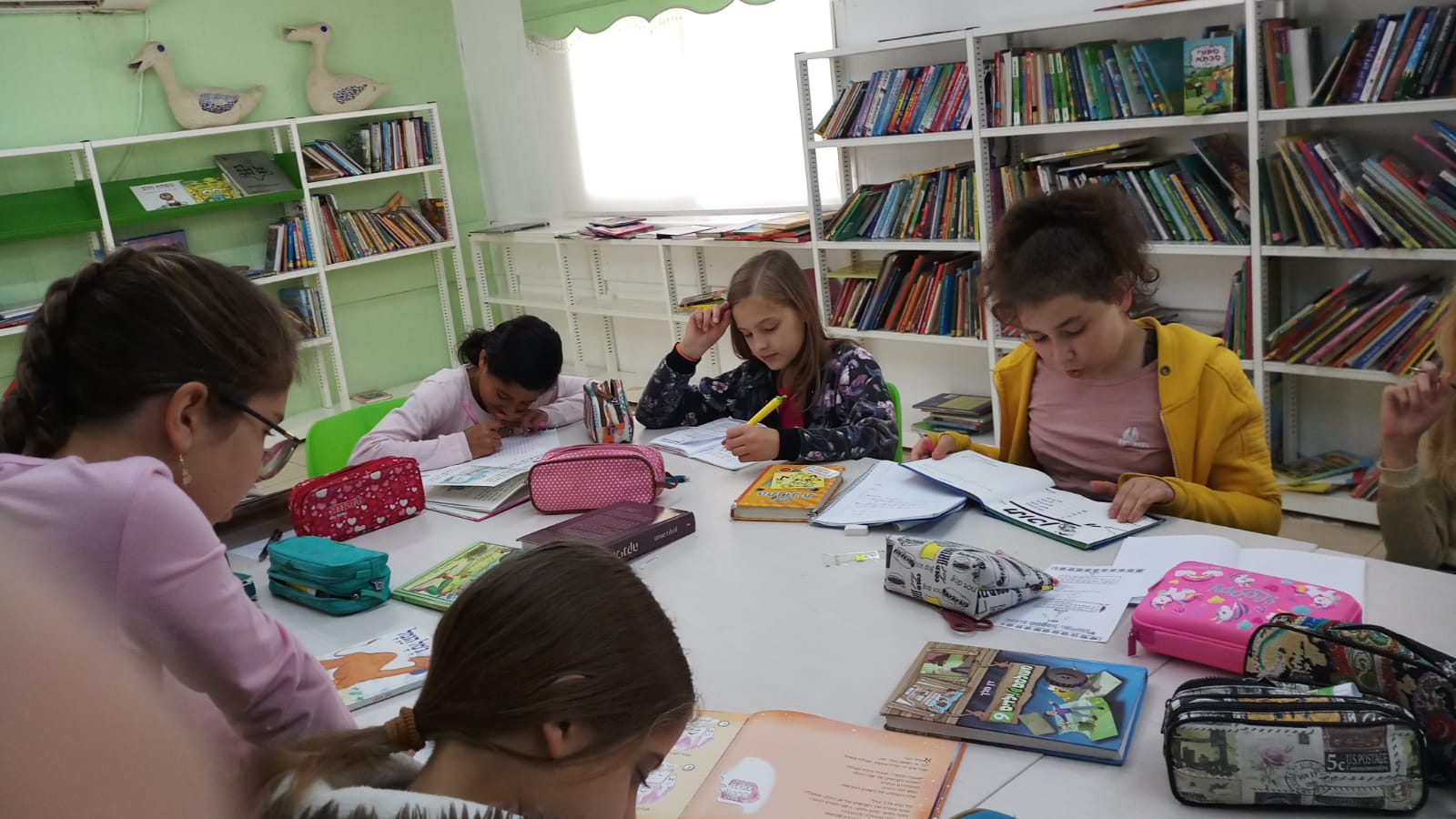 במסגרת קידום פרויקט קריאה המורה שושי יושבת עם התלמידות בספריה.