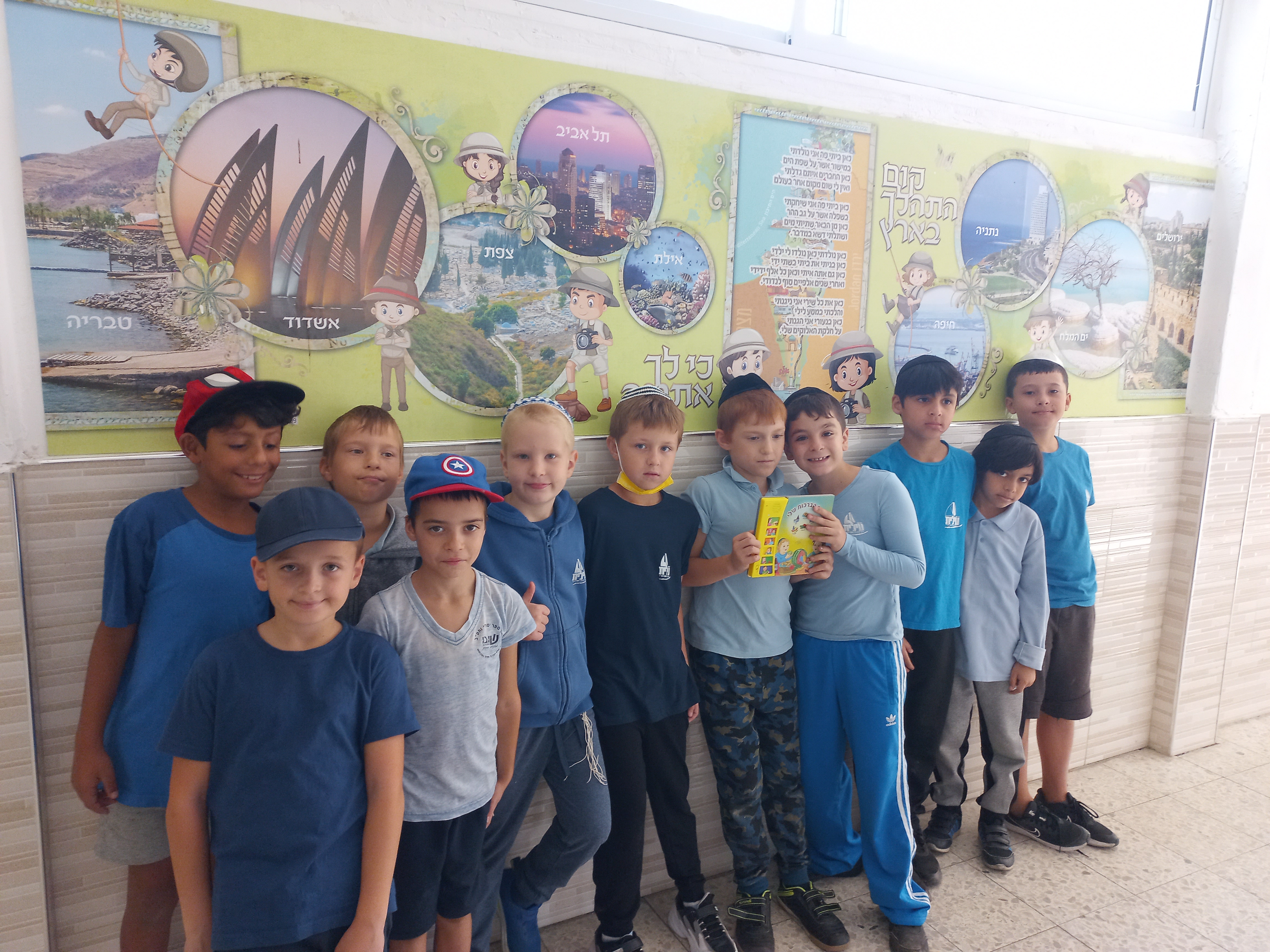 כיתה ה' מקבלת מתנה מהמנהלת ספר מנגן לכל כיתה.